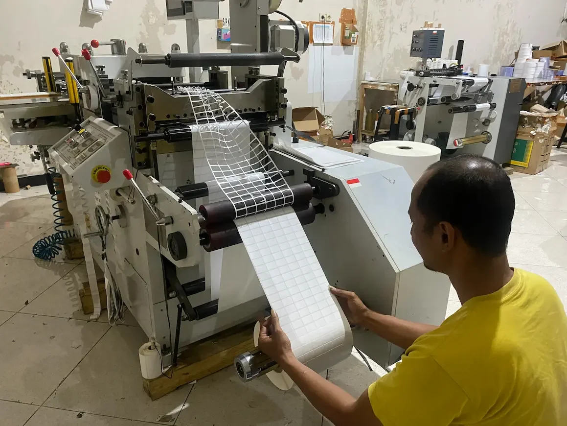 Proses produksi dan pemotongan material label barcode menggunakan mesin industri di pabrik Union Label Barcode Surakarta